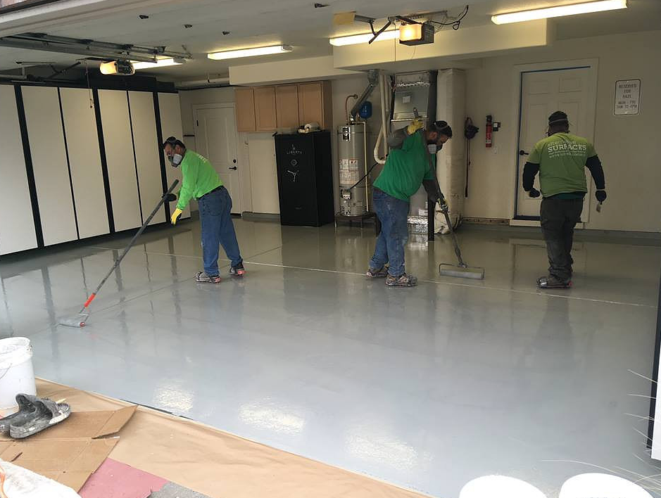 Crew rolling out a garage floor base coat